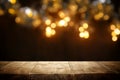 rustic wooden table in front of glitter black and gold bokeh lights. Royalty Free Stock Photo