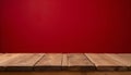 Rustic wooden table with natural grain against a deep red wallpaper background Royalty Free Stock Photo