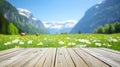 Rustic wooden table overlooking scenic mountain pasture with daisies and cattle in spring Royalty Free Stock Photo
