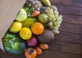 A rustic wooden table with a paper bag full of lots of freshly picked fresh fruit. Many vitamins together on a wooden table