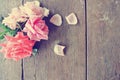 Rustic wooden table with pink roses and rose petals Royalty Free Stock Photo