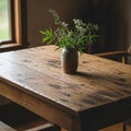 A rustic wooden table with a rough texture holds a small, ceramic vase. The vase Royalty Free Stock Photo