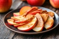 On a rustic wooden table, sliced apples are accompanied by a side of creamy peanut butter for a nutritious snack Royalty Free Stock Photo