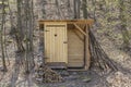 Rustic wooden toilet in the forest with a heart-shaped hole in the door boards. Royalty Free Stock Photo