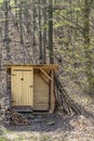 Rustic wooden toilet in the forest with a heart-shaped hole in the door boards. Royalty Free Stock Photo