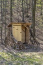 Rustic wooden toilet in the forest with a heart-shaped hole in the door boards. Royalty Free Stock Photo