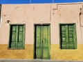 Rustic yellow country house with an old green door and windows in Puerto de la Cruz in Tenerife