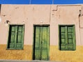 Rustic yellow country house with an old green door and windows in Puerto de la Cruz in Tenerife