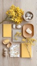 Rustic yellow and neutral palette with flowers, stones, and wooden elements on tabletop Royalty Free Stock Photo