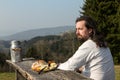 Rustically long-haired man is snacking healthy food