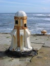 Rusting capstan on sea wall