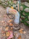 Rusting fire hydrant pipe next to stone wall Royalty Free Stock Photo