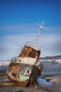 The rusting old boat on the rocks