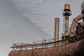 Rusting pipes with catwalks and railings, smokestacks in industrial complex Royalty Free Stock Photo