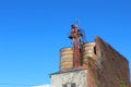 Rusting silos and brick facade against a blue sky Royalty Free Stock Photo