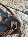 Rusting steel cable arcs through eye bolt Royalty Free Stock Photo