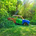 Rusty abandoned car wreck in the woods. Forest game dev background Royalty Free Stock Photo