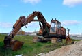 Rusty abandoned construction excavator with a bucket on the ground against the blue sky Royalty Free Stock Photo