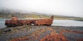 Rusty and abandoned old ship wreck from world war two laying on land in Mjoifjordur Royalty Free Stock Photo