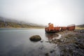 Rusty and abandoned old ship wreck from world war two laying on land in Mjoifjordur