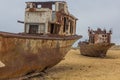 Rusty abandoned ships at the Ship cemetery at the former Aral sea coast in Moynaq Mo ynoq or Muynak , Uzbekist Royalty Free Stock Photo