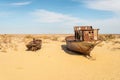 Rusty abandoned ships at the Ship cemetery at the former Aral sea coast in Moynaq Mo ynoq or Muynak , Uzbekistan Royalty Free Stock Photo