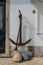 A rusty anchor hanging on a white wall