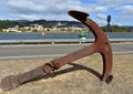 Rusty anchor in a road. River with small lighthouses and coastal village. Pontevedra, Galicia, Spain. Cloudy sky.