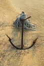 RUSTY ANCHOR WET BEACH SAND AND WHITE SEA WAVE FOAM Royalty Free Stock Photo