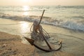 RUSTY ANCHOR WET BEACH SAND AND WHITE SEA WAVE FOAM Royalty Free Stock Photo