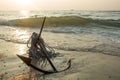 RUSTY ANCHOR WET BEACH SAND AND WHITE SEA WAVE FOAM Royalty Free Stock Photo