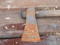 A rusty axe is lying on the table. The blade is clearly visible