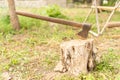 Rusty axe nailed to a log in the garden Royalty Free Stock Photo