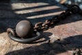 Rusty ball and chain on textured surface, shadows emphasize history and wear Royalty Free Stock Photo