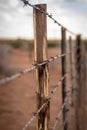 Rusty barb wire fence and old wood poles Royalty Free Stock Photo
