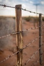 Rusty barb wire fence and old wood poles Royalty Free Stock Photo