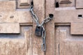 Rusty black padlock on a chain on an old vintage wooden closed door Royalty Free Stock Photo