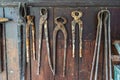 Rusty tools of the blacksmith hanging on a wooden plank Royalty Free Stock Photo