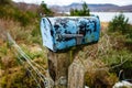 A rusty blue mailbox on the side of a road in remote scottish village Royalty Free Stock Photo