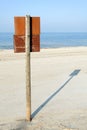 Rusty board sign on wooden post on a beach Royalty Free Stock Photo