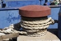 A rusty bollard with ropes. Fishing boats moor here in the port Royalty Free Stock Photo