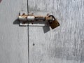 Rusty bolt with padlock on an old door Royalty Free Stock Photo