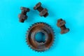 Rusty bolts, nuts and gear wheel made of chocolate isolated on blue background