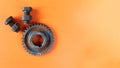 Rusty bolts, nuts and gear wheel made of chocolate isolated on orange background