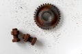 Rusty bolts, nuts and gear wheel made of chocolate isolated on white background