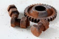 Rusty bolts, nuts and gear wheel made of chocolate on white background