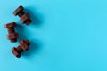 Rusty bolts and nuts made of chocolate isolated on sky blue background