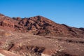 Rusty brown barren desert landscape under a clear blue sky