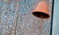 Rusty brown bell near old dark cyan wooden closed door of a traditional house in Asia Royalty Free Stock Photo