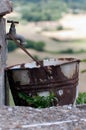 Rusty bucket in an old vintage outdoor faucet without water